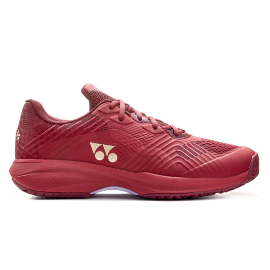 Red Yonex tennis shoe with a brand logo on a white background