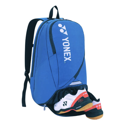 Blue Yonex backpack with a white and orange shoe inside on a white background