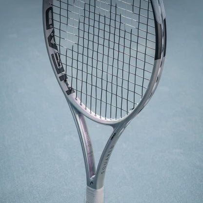 Silver tennis racket with 'HEAD' branding on a light blue background