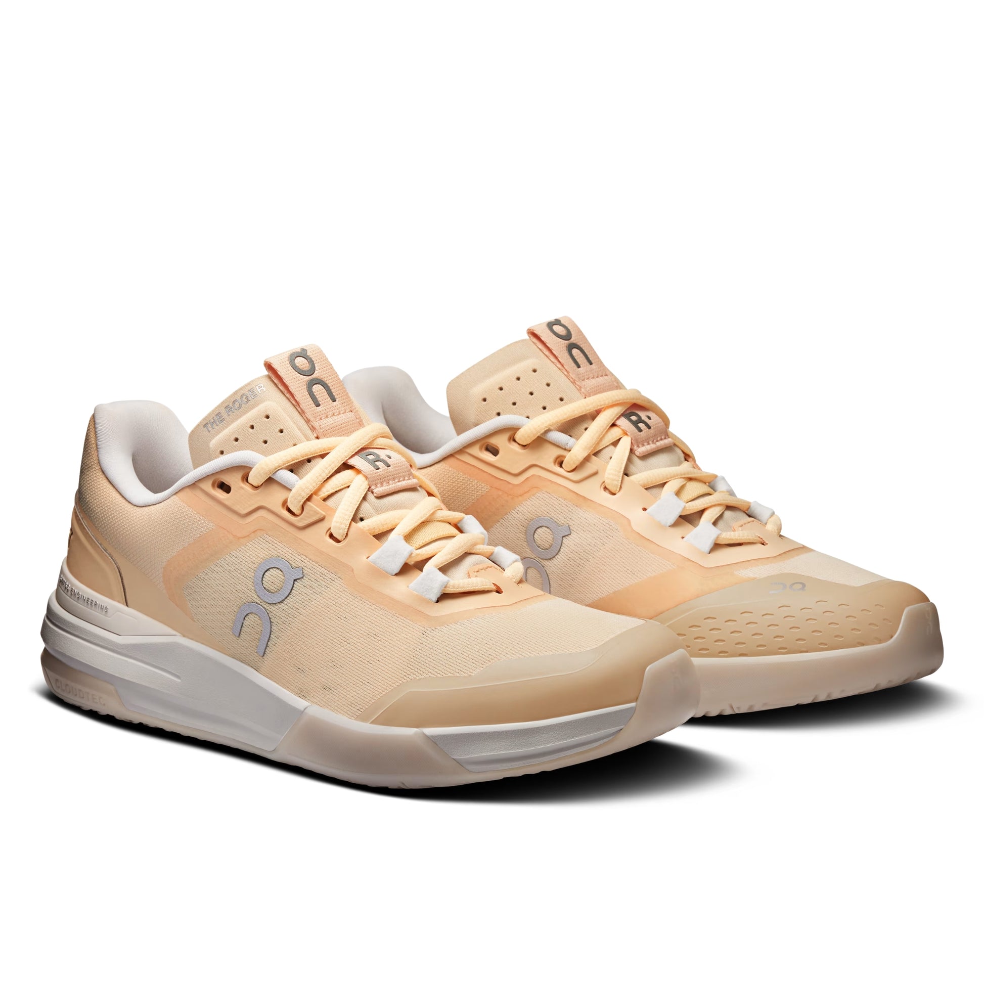 A pair of On running shoes in a warm peach and beige colorway, featuring the brand's signature 'on' logo on the side and tongue, set against a clean white background.