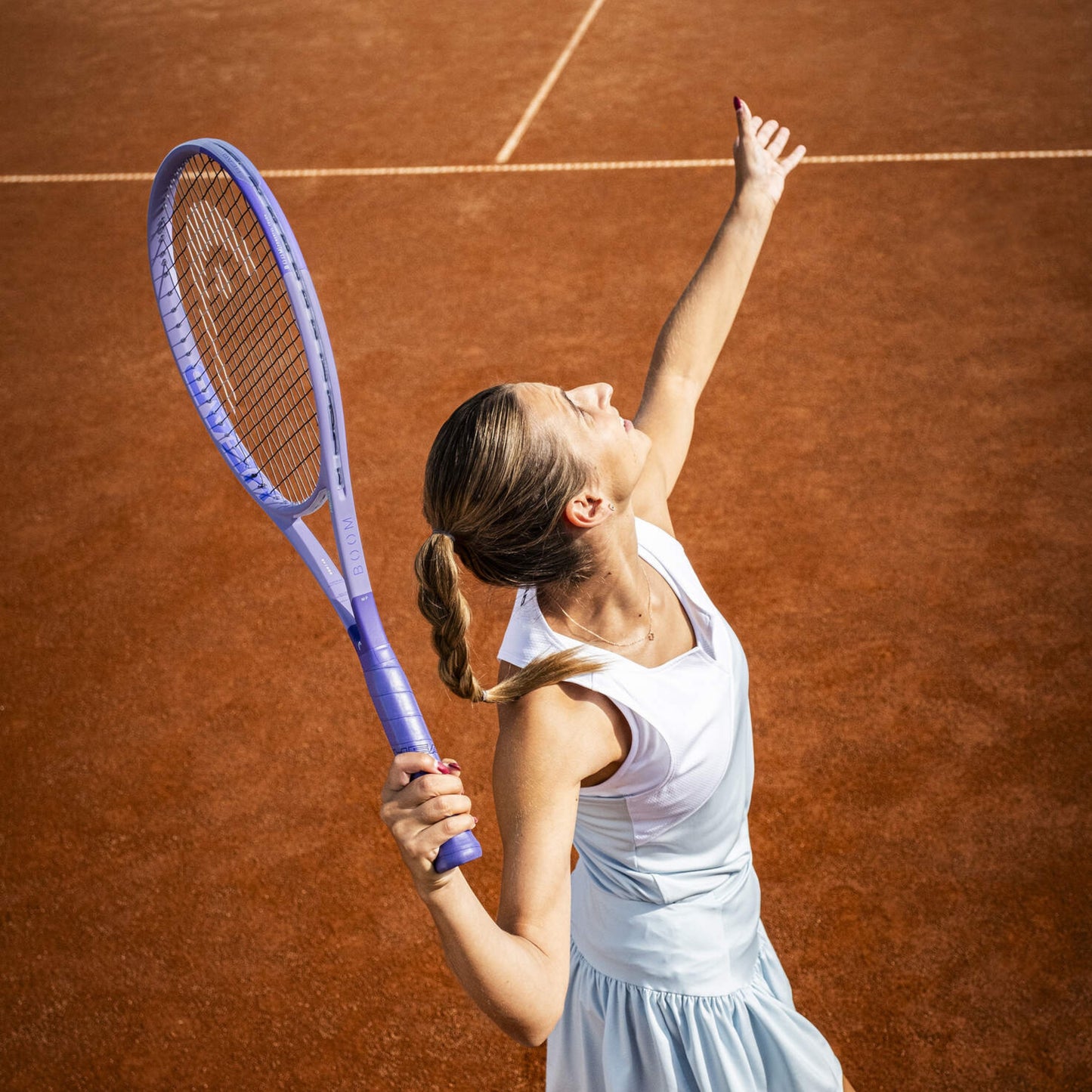 Woman on a tennis court holding a racket with a white background