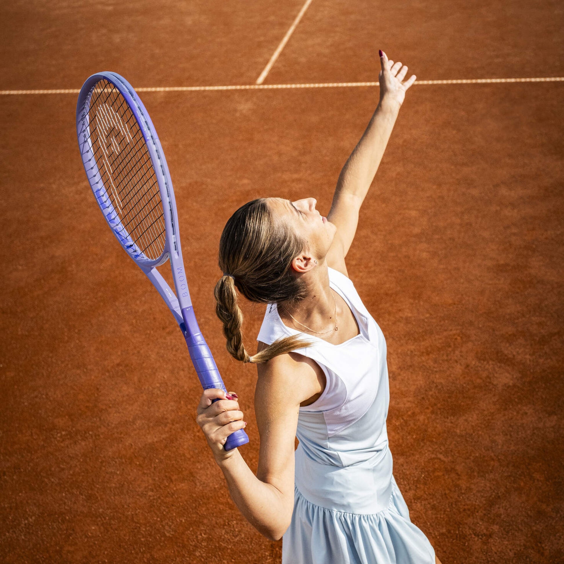 Woman on a tennis court holding a racket with a white background