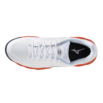 A top-down view of a white Mizuno tennis shoe with orange accents on the midsole and heel, and a black interior lining.
