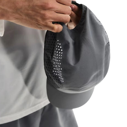 Person holding a grey On cap on a white background