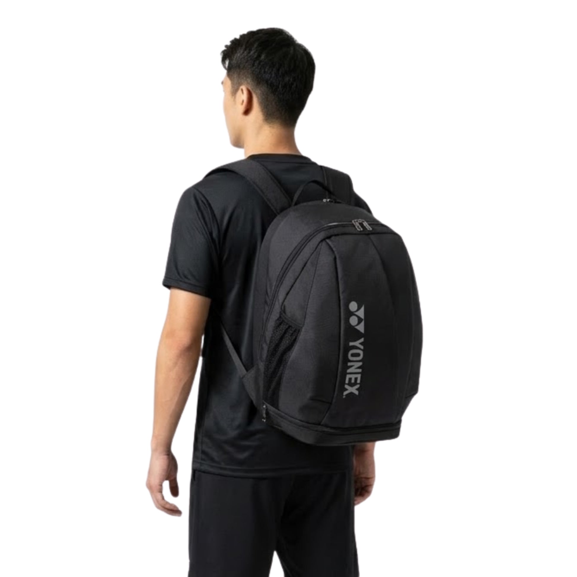 Person wearing a black Yonex backpack on a white background
