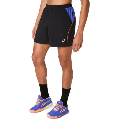 Person wearing black athletic shorts with blue accents and blue running shoes on a white background
