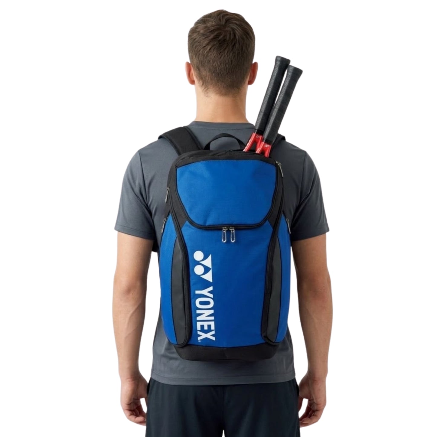 Person wearing a blue Yonex backpack with tennis rackets on a white background