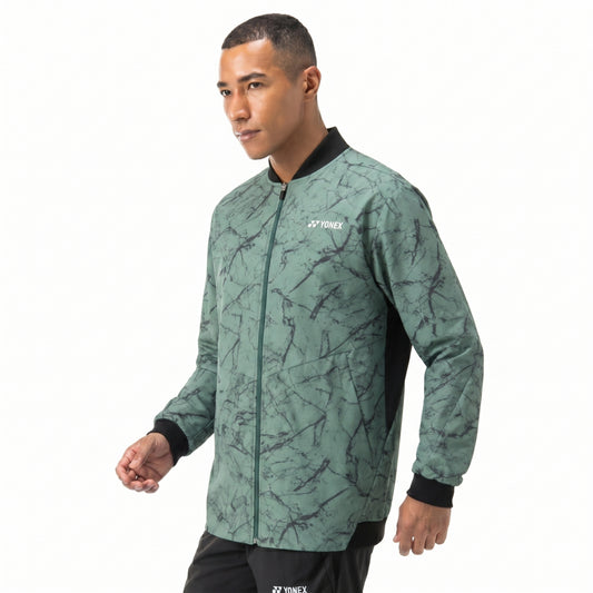Man wearing a green patterned jacket with Yonex logo on a white background