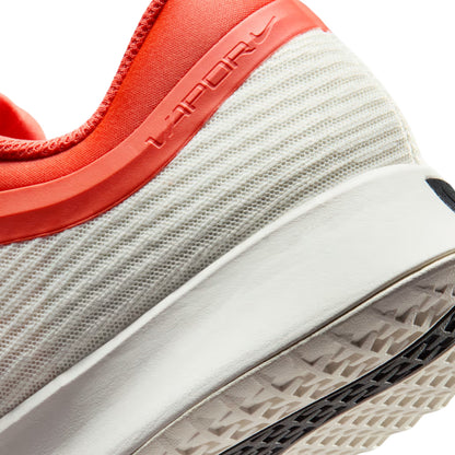 Close-up of a orange and white Nike shoe on a white background