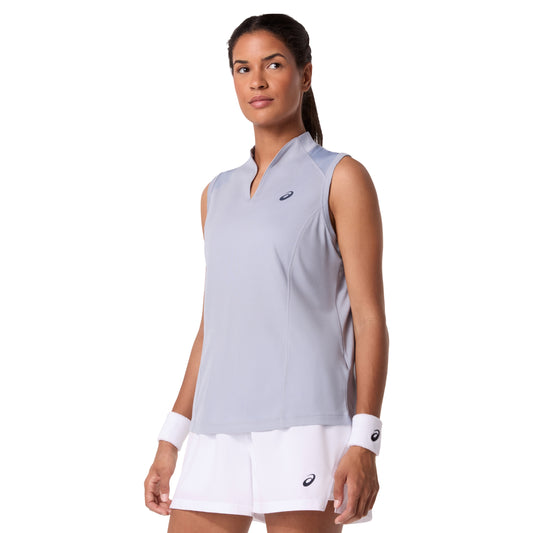 Woman wearing a light gray sleeveless Asics top and white shorts with a visible brand logo on a white background