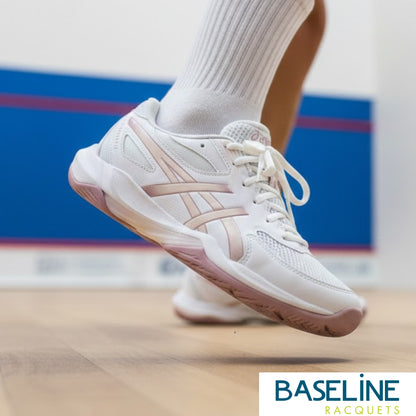 White squash shoe on a court with 'Baseline Racquets' branding.