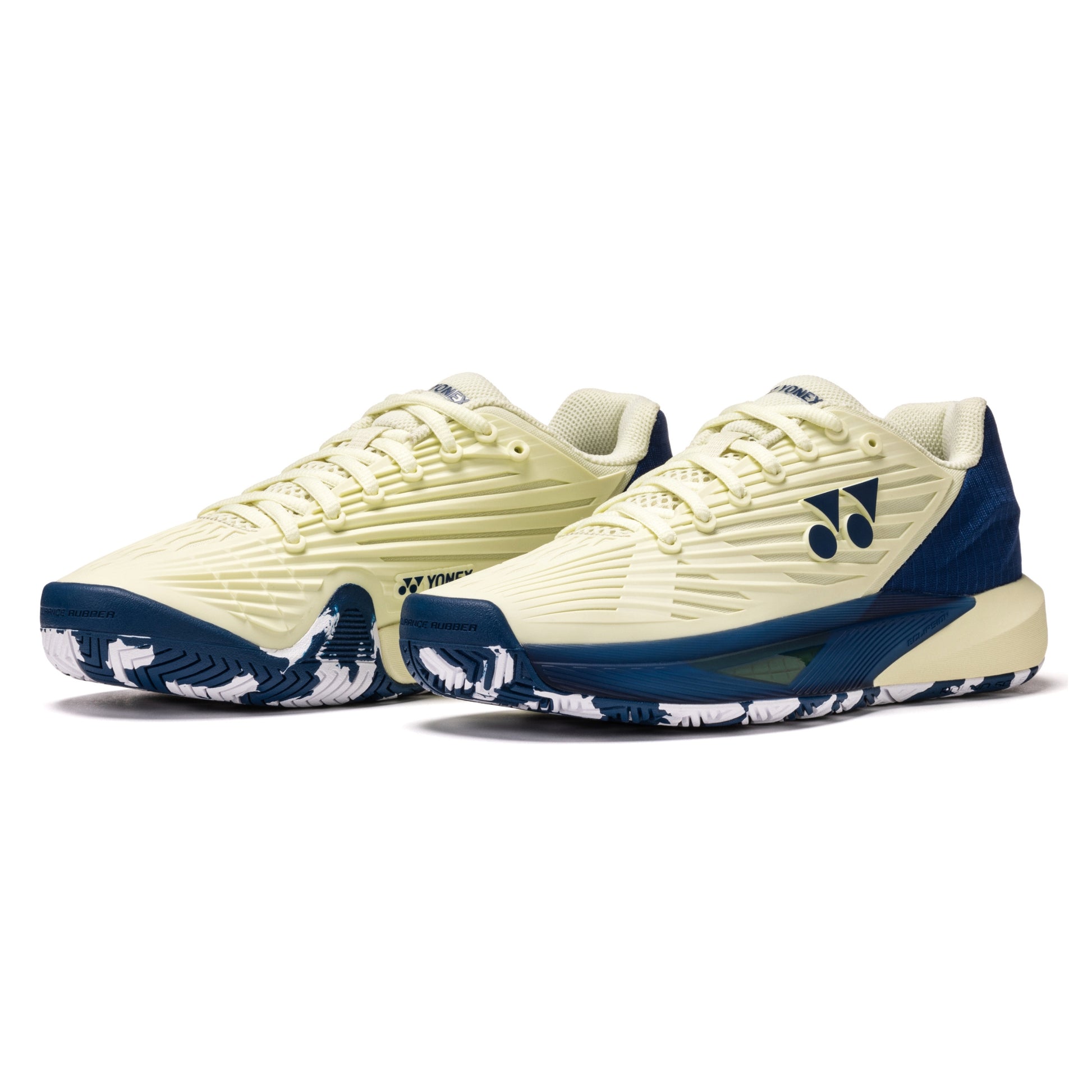 Pair of cream and navy Yonex tennis shoes on a white background