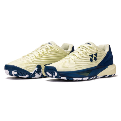 Pair of cream and navy Yonex tennis shoes on a white background