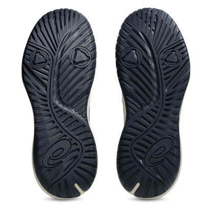 The outsoles of a pair of tennis shoes, shown from the bottom against a plain white background. The soles are dark navy blue with a textured, ribbed pattern and a small white accent line along the edge.