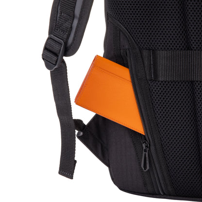 Black backpack with an orange item peeking out of a side pocket on a white background