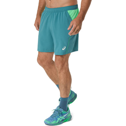 Person wearing teal shorts with a white background