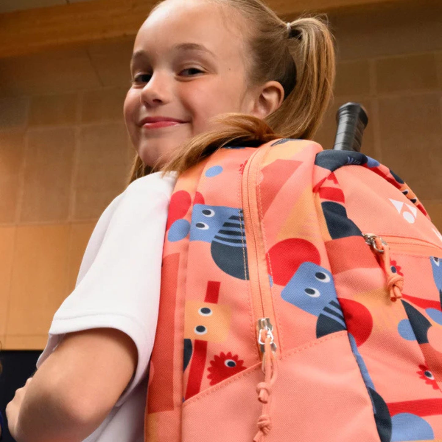 Young girl wearing a colorful backpack with abstract patterns