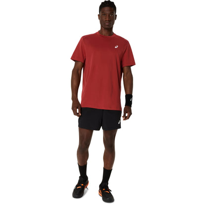 Man wearing a red athletic shirt and black shorts on a white background