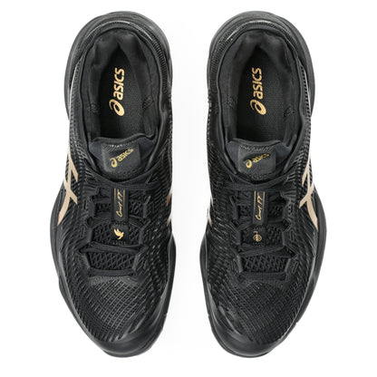 Black tennis shoes with gold accents on a white background