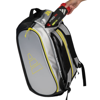 Gray bag with black accents being held open by a hand, displaying an Adidas Speed RX tennis racket.