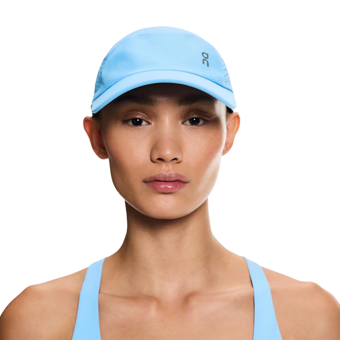 Woman wearing a blue On cap on a white background
