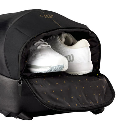 Black backpack with white tennis shoes inside, featuring a brand logo on the top.