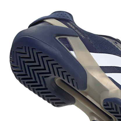 Close-up of a blue and beige adidas tennis shoe with textured sole on a white background