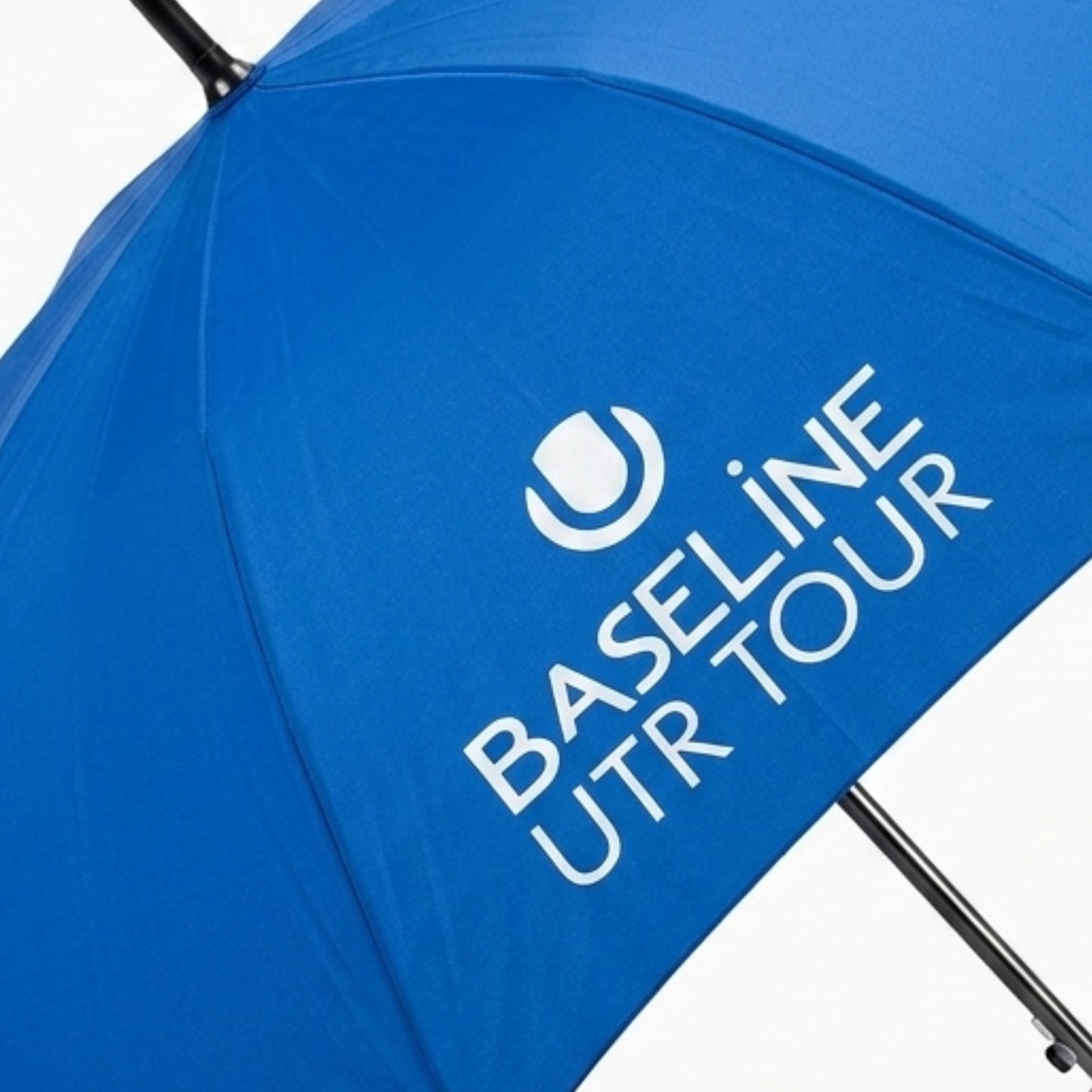 Blue umbrella with White Baseline UTR Tour logo