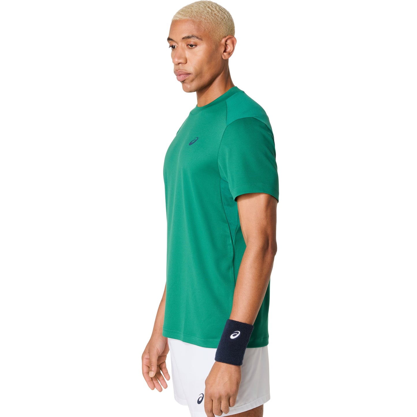 Person wearing a green Asics athletic shirt with a logo on a white background