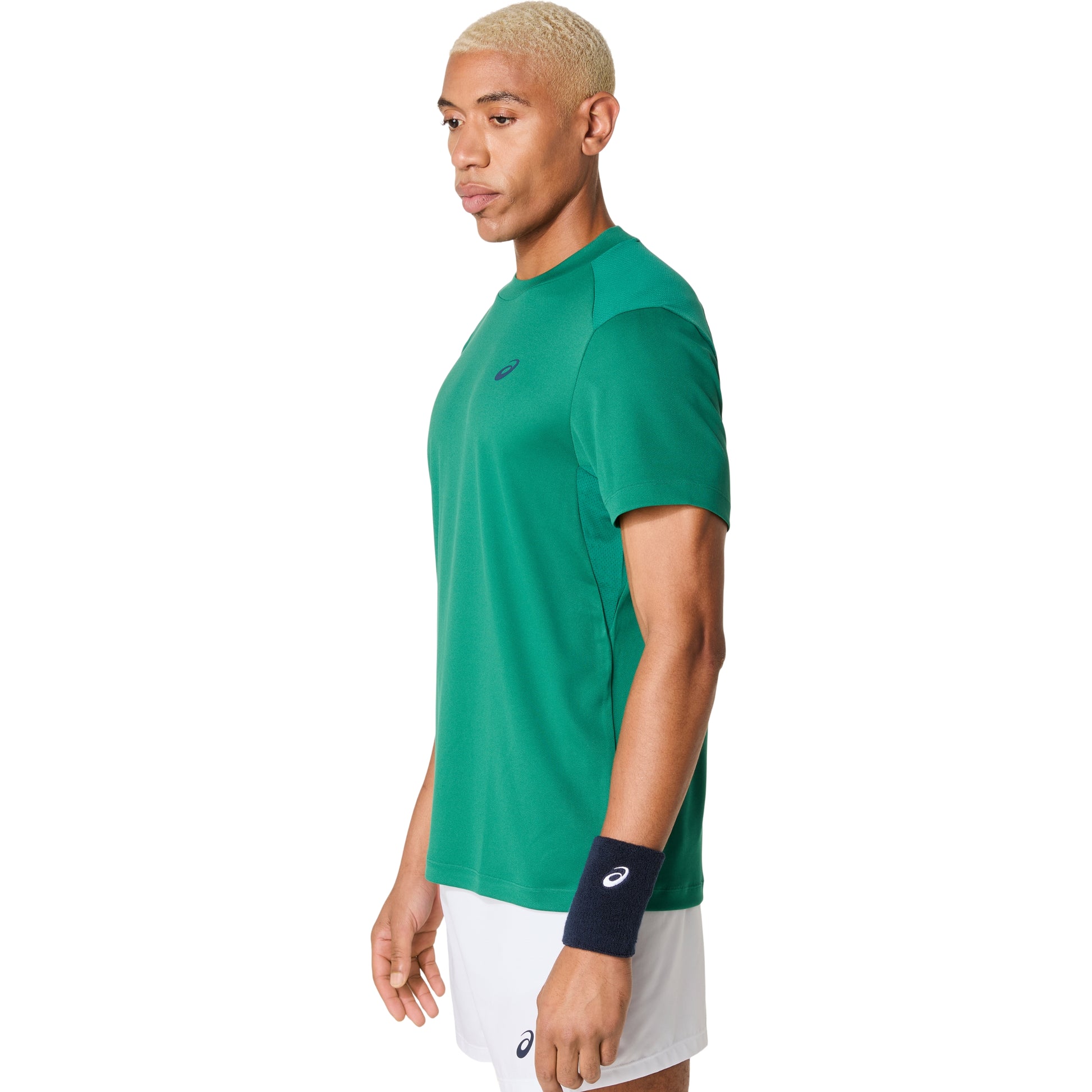 Person wearing a green Asics athletic shirt with a logo on a white background