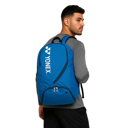 Man wearing a blue Yonex backpack on a white background